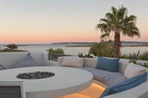 a living room with a couch and a table on a balcony at Parian Boutique Hotel in Naousa