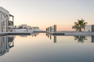 a view of a pool of water with houses and palm trees at Parian Boutique Hotel in Naousa