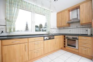 a kitchen with wooden cabinets and a large window at Apartment Hohenstaufen in Göppingen