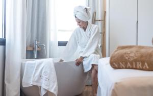 a woman in a bathtub in a hotel room at Ynaira hotel & Spa in Ariany