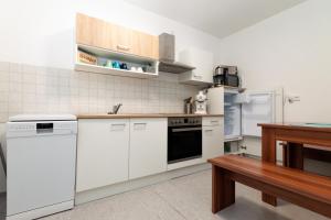 a kitchen with white appliances and a wooden table at Ferienwohnung Zschopau für Sie vollausgestattet mit Boxspringbett Netflix uvm in Zschopau