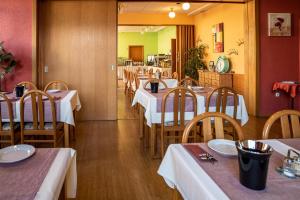 a restaurant with tables and chairs with white tablecloths at Hotel Mainperle in Wertheim