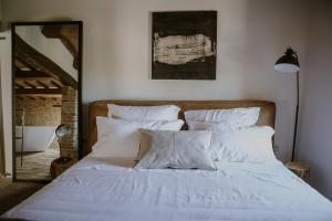 een bed met witte lakens en kussens in een slaapkamer bij Borgo Loretello in Loretello