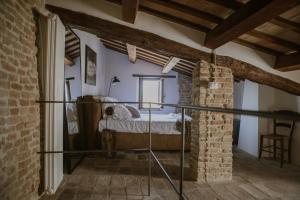 1 dormitorio con 1 cama en una pared de ladrillo en Borgo Loretello en Loretello