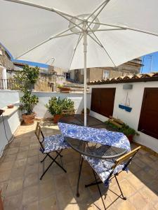Residenza Eos في سيراكوزا: طاولة وكراسي مع مظلة على الفناء
