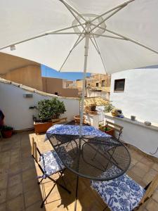 a table and chairs under an umbrella on a patio at Residenza Eos in Syracuse