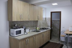 a kitchen with a microwave and a sink at Casa Coman Moisei in Moisei