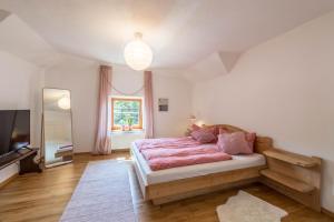 a bedroom with a large bed and a television at Traum-ferienwohnung in Siegsdorf