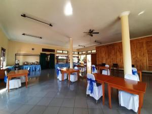 a dining room with tables and blue chairs at Hotel Mutiara Baru in Batu