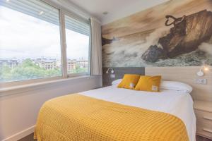 a bedroom with a bed and a large window at Pensión Riberas del Urumea in San Sebastián