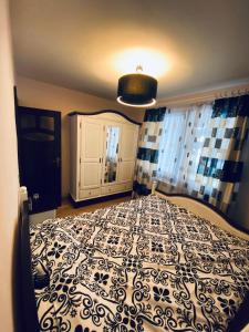 a bedroom with a bed with a black and white comforter at City Centre Apartment in Reghin