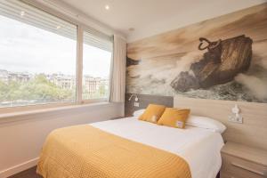 a bedroom with a bed and a painting on the wall at Pensión Riberas del Urumea in San Sebastián