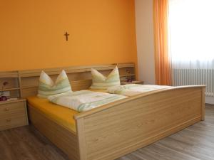 um quarto com uma cama de madeira com almofadas em Ferienwohnung Haus Wannenberg em Tengen