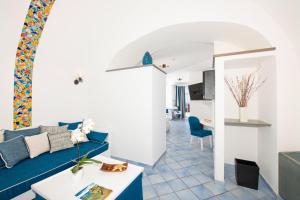 uma sala de estar com um sofá azul e uma mesa em Positano Art Hotel Pasitea em Positano