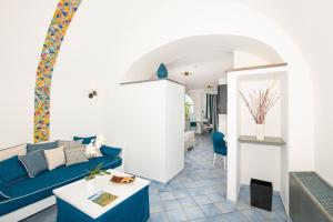 a living room with a blue couch and a table at Positano Art Hotel Pasitea in Positano