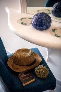 un cappello seduto su una sedia accanto a un tavolo di Positano Art Hotel Pasitea a Positano