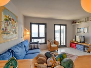 a living room with a blue couch and some windows at Exclusive front line apartment in Calella de Palafrugell