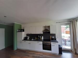 una cucina con mobili bianchi e un forno a piano cottura di Ferienhaus Malte Büsch a Barlt Altre 3 foto