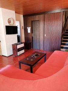 un soggiorno con divano rosso e tavolo di Guesthouse Butković a Punat