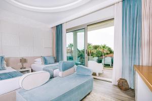 a bedroom with two beds and a balcony at Ilica Hotel Spa & Wellness Resort in Çeşme