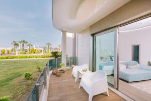 a balcony with white furniture and a view of the ocean at Ilica Hotel Spa & Wellness Resort in Çeşme