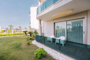 a house with a balcony with a table and chairs at Ilica Hotel Spa & Wellness Resort in Çeşme