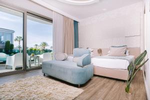 a bedroom with a bed and a couch and a chair at Ilica Hotel Spa & Wellness Resort in Çeşme