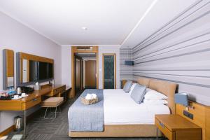a hotel room with a bed and a desk and a television at Ilica Hotel Spa & Wellness Resort in Çeşme