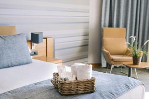a hotel room with a bed with a basket of towels at Ilica Hotel Spa & Wellness Resort in Çeşme