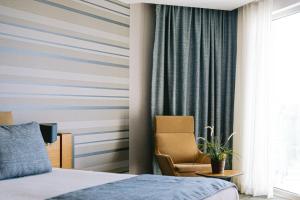 a hotel room with a bed and a chair at Ilica Hotel Spa & Wellness Resort in Çeşme