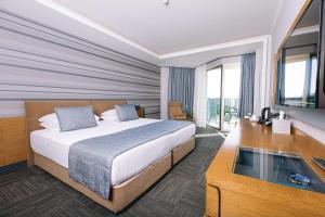a hotel room with a bed and a television at Ilica Hotel Spa & Wellness Resort in Çeşme