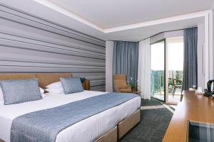 a hotel room with a bed and a balcony at Ilica Hotel Spa & Wellness Resort in Çeşme