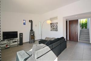 Una sala de estar con un sofá y un televisor. en Villa Domus, en Son Serra de Marina