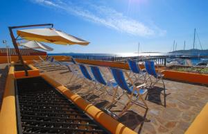 a group of chairs and an umbrella on a beach at Le Sirene in Marina di Portisco