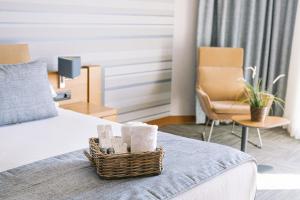 a hotel room with a bed and a basket of towels at Ilica Hotel Spa & Wellness Resort in Çeşme