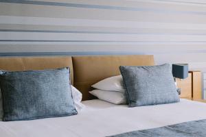 a bed with two pillows and a striped wall at Ilica Hotel Spa & Wellness Resort in Çeşme
