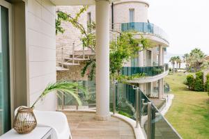a balcony with a building with a spiral staircase at Ilica Hotel Spa & Wellness Resort in Çeşme