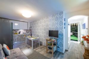 a living room with a tv and a kitchen at Zaffiro house in Minori