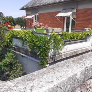 a retaining wall with plants on top of a house at Chambres d'hôtes GOBILLON in Maintenon