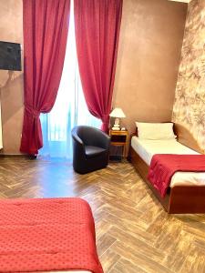 1 Schlafzimmer mit 2 Betten, einem Stuhl und einem Fenster in der Unterkunft Villa Pallotta Luxury B&B in Cerignola