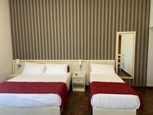 Habitación de hotel con 2 camas y espejo en Villa Pallotta Luxury B&B, en Cerignola