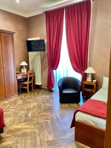 a hotel room with a bed and a chair and a desk at Villa Pallotta Luxury B&B in Cerignola