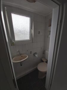 baño con lavabo y aseo y ventana en Haus Leonora, en Cuxhaven