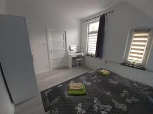 1 dormitorio con 1 cama, escritorio y ventanas en Haus Leonora, en Cuxhaven