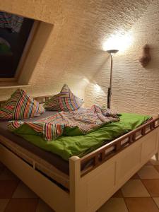 a bed with a green comforter and pillows on it at Salzoasen Apartment in Bad Schwartau