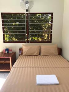 uma cama num quarto com uma grande janela em Manel Guesthouse and Restaurant em Sen Monorom