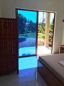 a bedroom with a door open to a yard at Manel Guesthouse and Restaurant in Sen Monorom