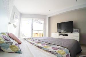 ベナルマデナにあるCasa de Locosのベッドルーム1室(ベッド1台、薄型テレビ付)