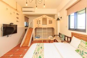 Habitación pequeña con cama y casa de juegos en 新斑鳩小鎮親子民宿, en Wujie
