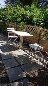een tafel en twee stoelen naast een hek bij Gemütliche wohnung in Bühl